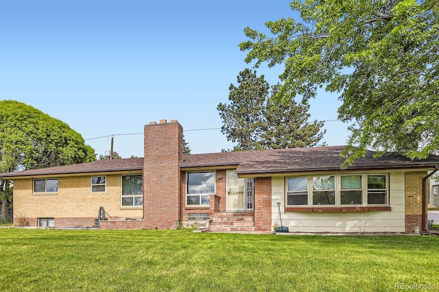 555 W Mansfield Ave, Englewood, CO 80110 - view of front of house featuring a front yard, a chimney, and brick siding