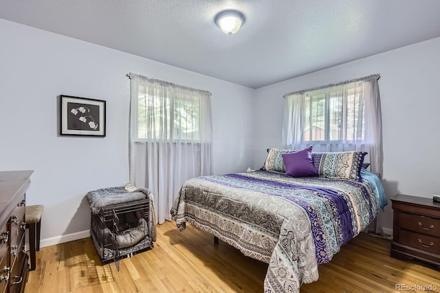 555 W Mansfield Ave, Englewood, CO 80110 - bedroom with multiple windows, wood finished floors, and baseboards
