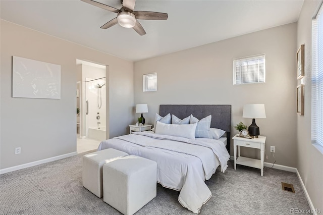 carpeted bedroom with multiple windows, ceiling fan, and connected bathroom