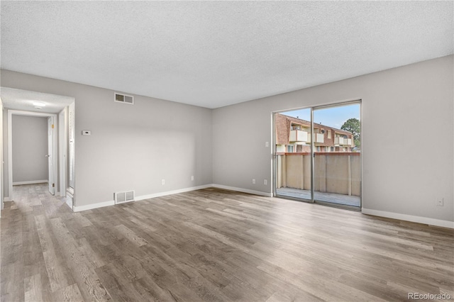 10211 Ura Ln Unit 1-202, Thornton, CO 80260 - unfurnished living room with wood finished floors, a textured ceiling, and baseboards