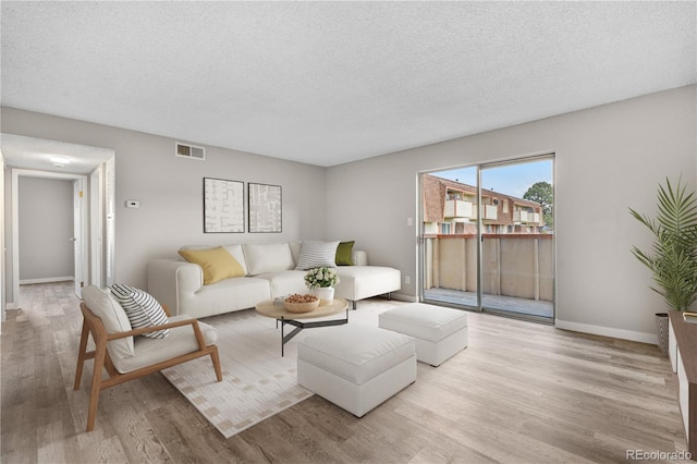 10211 Ura Ln Unit 1-202, Thornton, CO 80260 - living area featuring wood finished floors, a textured ceiling, and baseboards