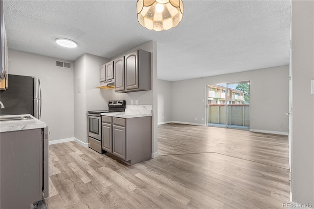 10211 Ura Ln Unit 1-202, Thornton, CO 80260 - kitchen featuring stainless steel appliances, gray cabinetry, a textured ceiling, under cabinet range hood, and light countertops