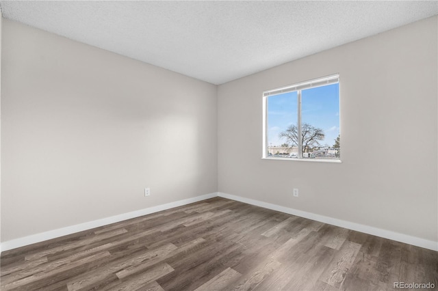10211 Ura Ln Unit 1-202, Thornton, CO 80260 - empty room with wood finished floors, baseboards, and a textured ceiling