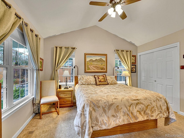 bedroom with a closet, lofted ceiling, light carpet, baseboards, and ceiling fan