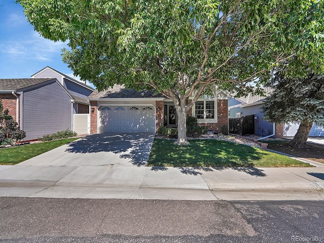 obstructed view of property with fence, a front yard, brick siding, concrete driveway, and an attached garage