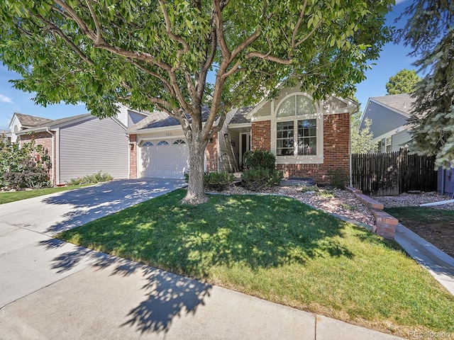 view of property hidden behind natural elements with a garage, a front lawn, fence, brick siding, and driveway