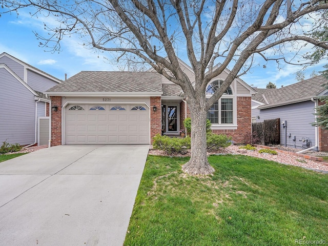 ranch-style home with a garage, a front yard, driveway, and brick siding