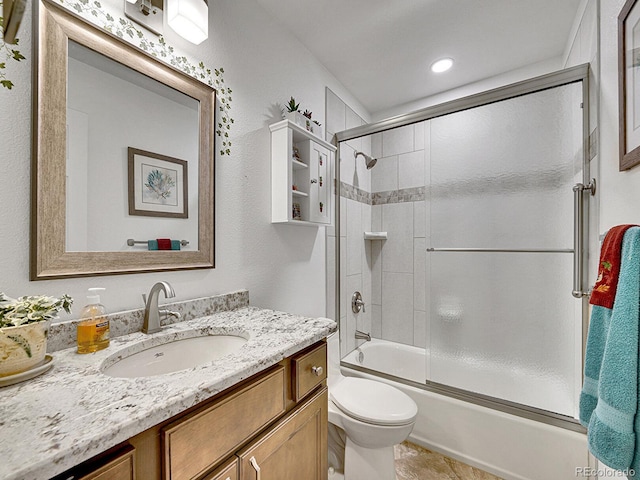 bathroom featuring vanity, tile patterned floors, toilet, and shower / bath combination with glass door
