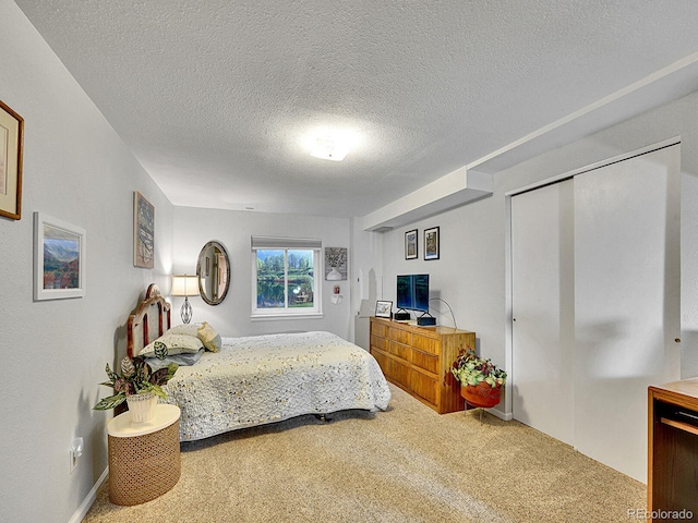 bedroom with carpet floors and a textured ceiling