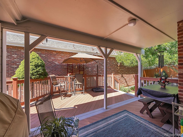wooden terrace featuring outdoor dining area and fence