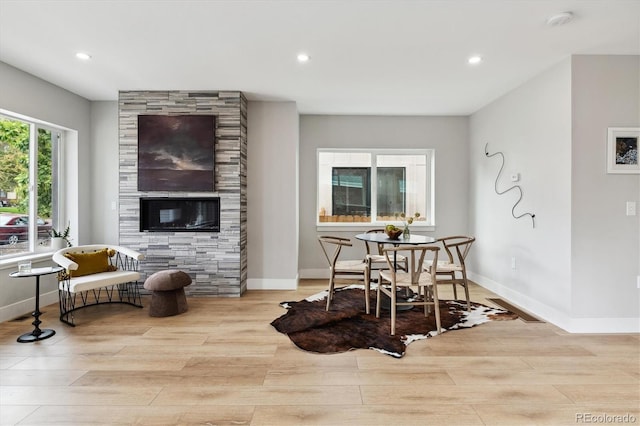 living room featuring a large fireplace and light wood-type flooring