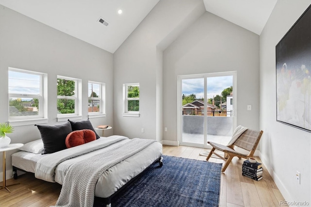 bedroom with access to exterior, high vaulted ceiling, and light hardwood / wood-style flooring