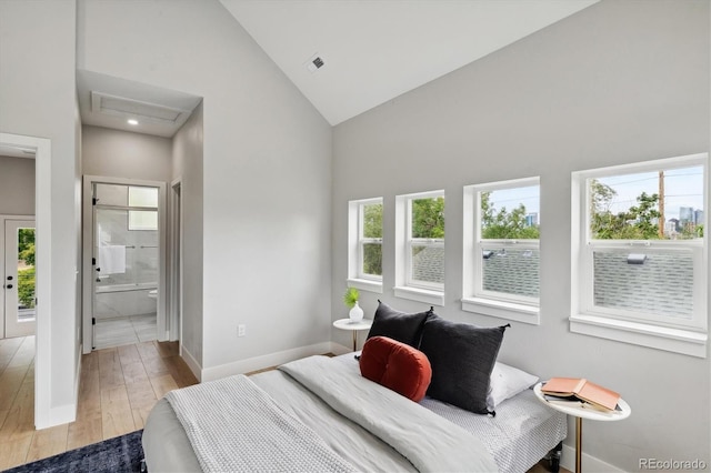 bedroom featuring ensuite bathroom, high vaulted ceiling, and light hardwood / wood-style flooring