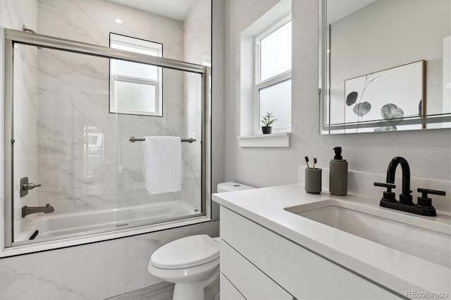 full bathroom with vanity, combined bath / shower with glass door, and toilet