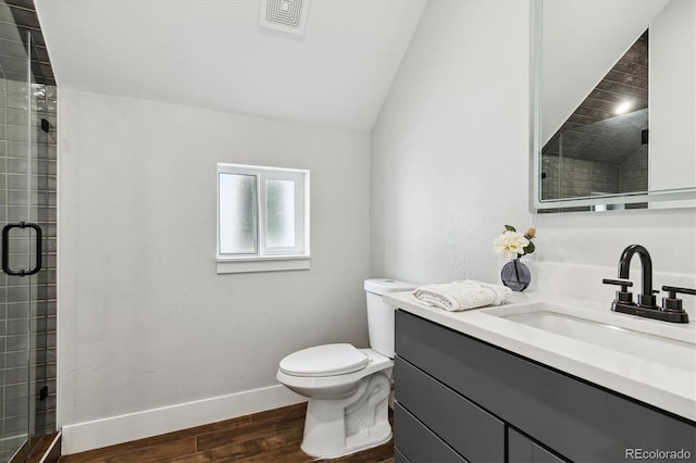 bathroom featuring vaulted ceiling, hardwood / wood-style flooring, vanity, toilet, and a shower with door