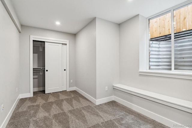 unfurnished bedroom featuring carpet floors and a closet