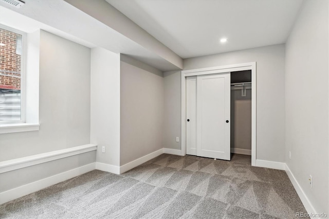 unfurnished bedroom featuring light colored carpet and a closet