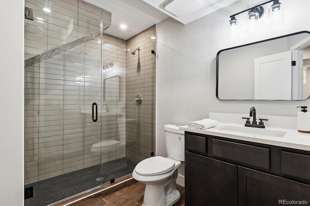 bathroom featuring vanity, hardwood / wood-style floors, toilet, and walk in shower