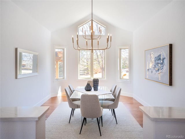 dining space featuring light wood-type flooring, plenty of natural light, and lofted ceiling