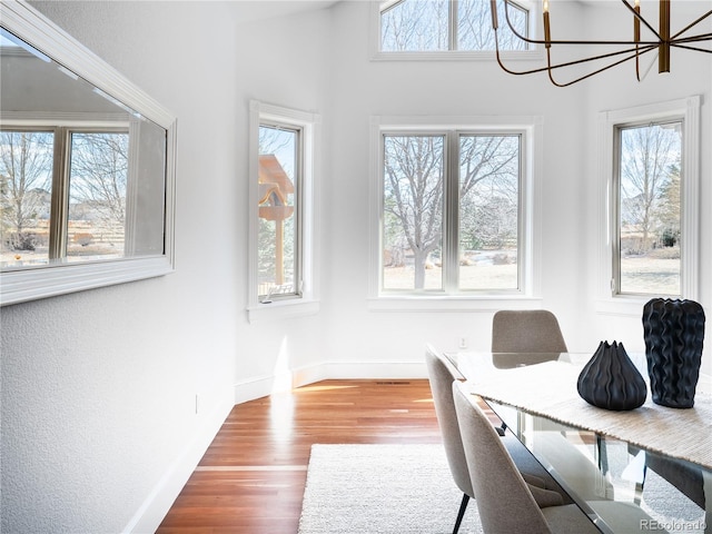 home office with a chandelier, hardwood / wood-style floors, and a healthy amount of sunlight