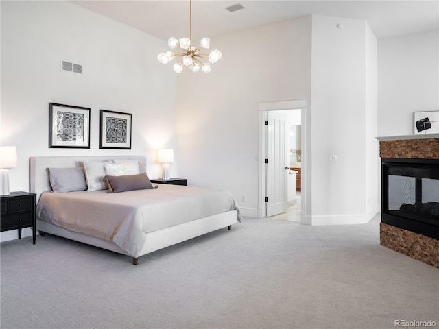 bedroom featuring light colored carpet, an inviting chandelier, a multi sided fireplace, and a high ceiling