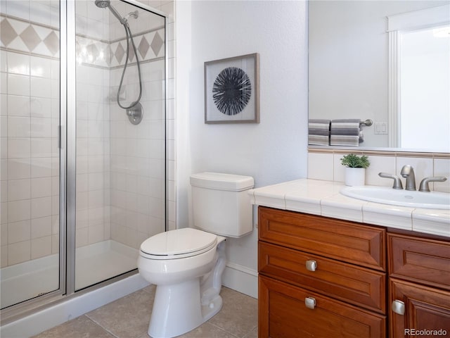 bathroom featuring vanity, tile patterned flooring, toilet, and a shower with door