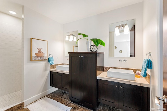 bathroom with vanity and tiled shower