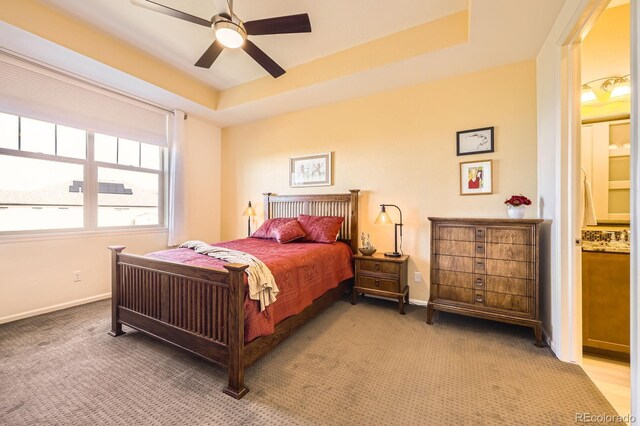 16459 W 86th Pl Unit B, Arvada, CO 80007 - bedroom with light carpet, a raised ceiling, ensuite bathroom, baseboards, and ceiling fan