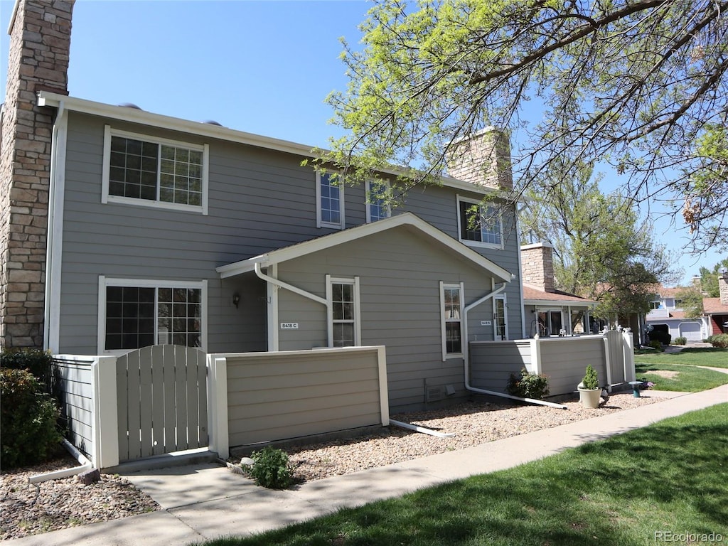 8418 Everett Way Unit C, Arvada, CO 80005 - rear view of house featuring a chimney, fence, and a gate