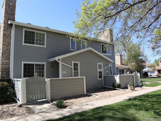 8418 Everett Way Unit C, Arvada, CO 80005 - rear view of house featuring a chimney, fence, and a gate