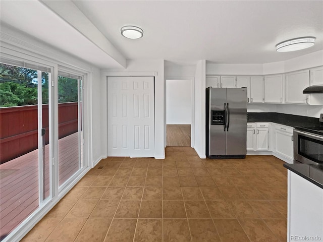 9115 W Hinsdale Pl, Littleton, CO 80128 - kitchen with appliances with stainless steel finishes, dark countertops, light tile patterned floors, under cabinet range hood, and white cabinetry
