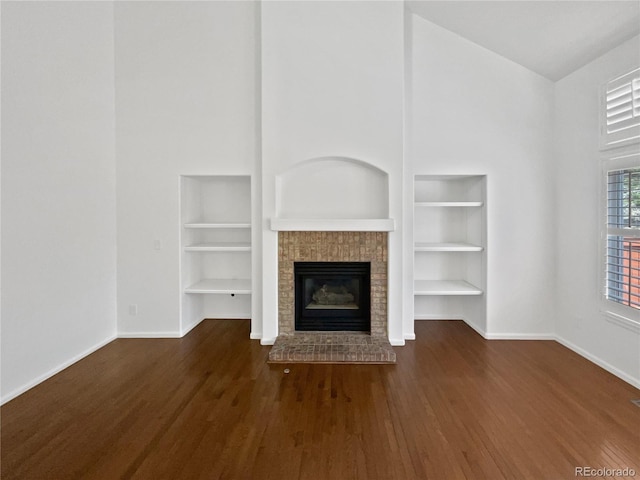 9115 W Hinsdale Pl, Littleton, CO 80128 - unfurnished living room featuring built in features, baseboards, wood finished floors, and a high ceiling