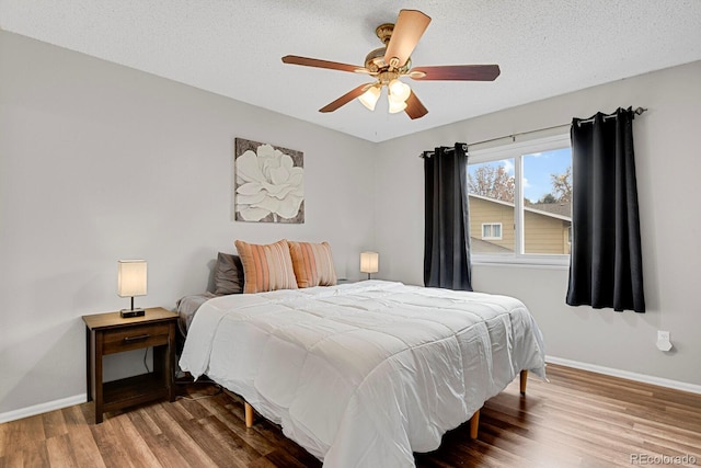 bedroom with wood-type flooring, a textured ceiling, and ceiling fan