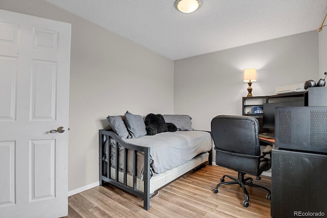 bedroom with hardwood / wood-style floors and a textured ceiling