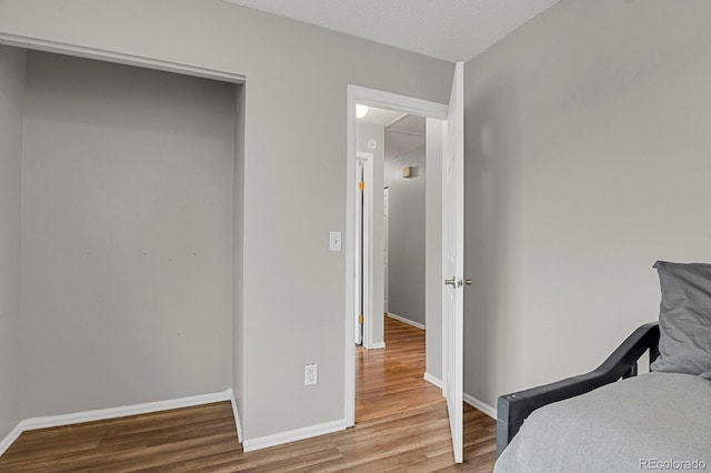 bedroom with hardwood / wood-style floors and a textured ceiling