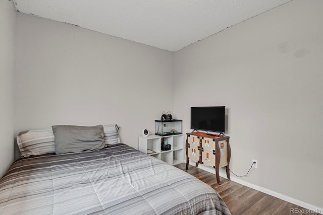 bedroom with wood-type flooring and a textured ceiling