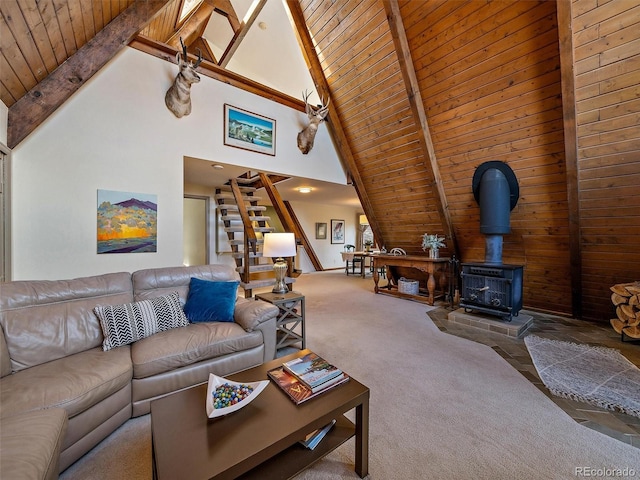 carpeted living room featuring high vaulted ceiling, a wood stove, wooden ceiling, and beam ceiling