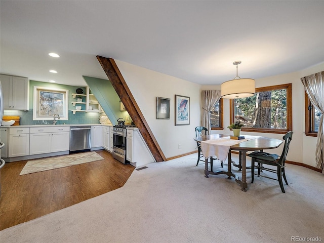 dining space with sink and dark colored carpet