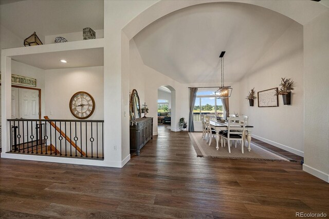 1248 Rawhide Cir, Elizabeth, CO 80107 - dining area featuring arched walkways, dark wood finished floors, a chandelier, high vaulted ceiling, and recessed lighting