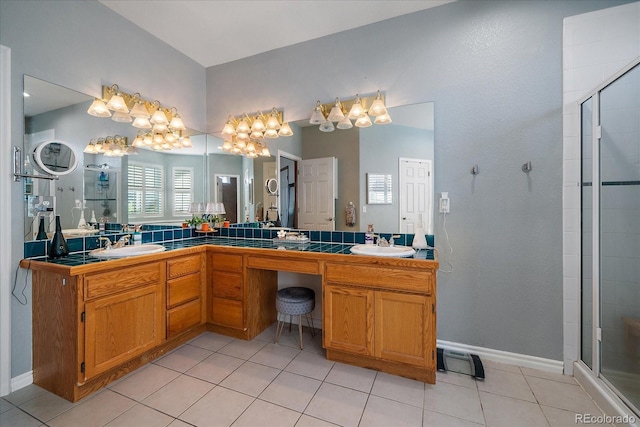 1248 Rawhide Cir, Elizabeth, CO 80107 - bathroom featuring tile patterned flooring, double vanity, a shower stall, and a chandelier