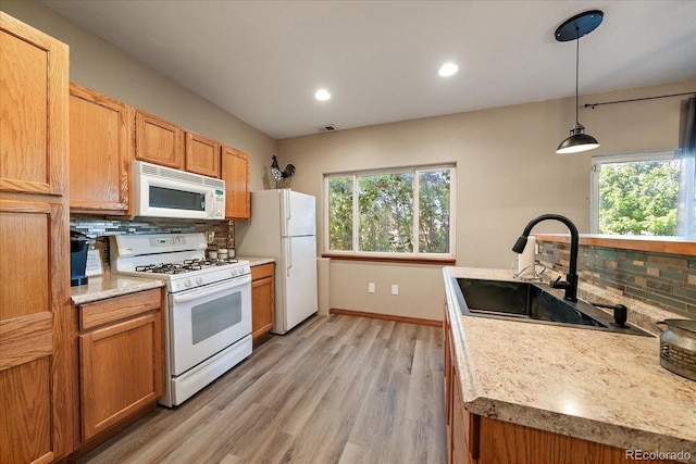 1248 Rawhide Cir, Elizabeth, CO 80107 - kitchen featuring white appliances, backsplash, healthy amount of natural light, light countertops, and recessed lighting