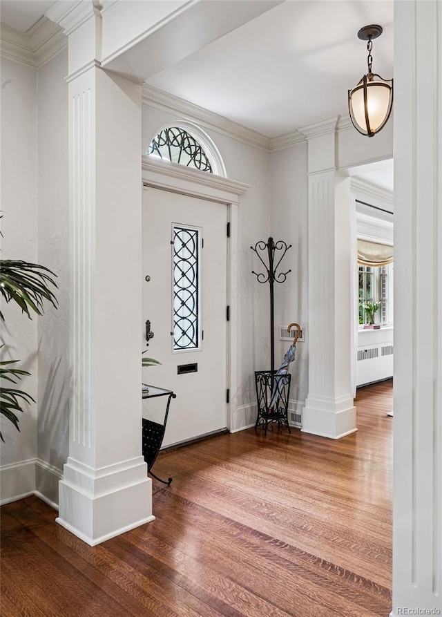 6300 E 17th Avenue Parkway, Denver, CO 80220 - foyer entrance with radiator heating unit, ornate columns, wood finished floors, and ornamental molding