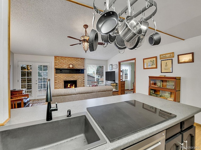 kitchen with open floor plan, light countertops, a textured ceiling, and a fireplace