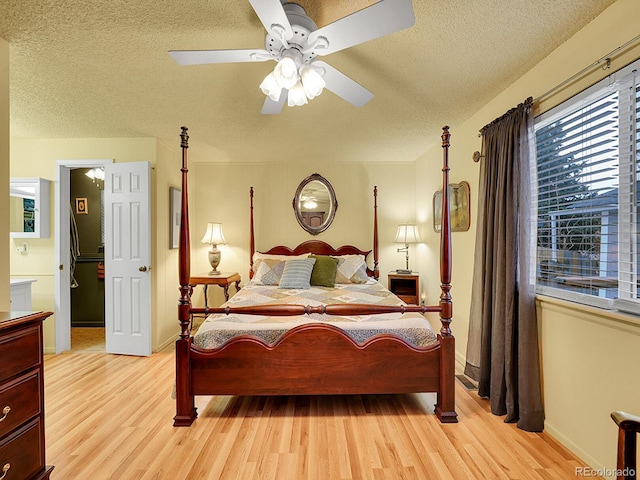 bedroom featuring ceiling fan, a textured ceiling, and light wood finished floors