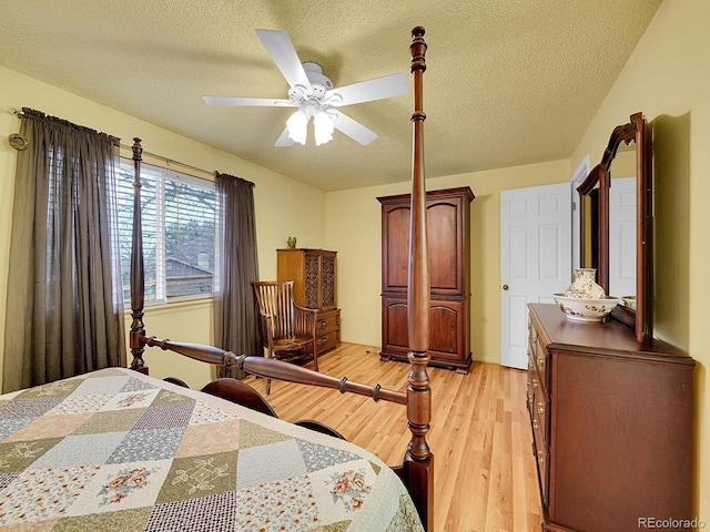 bedroom featuring a ceiling fan, light wood-style flooring, and a textured ceiling