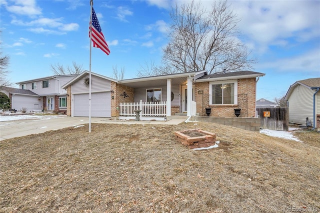 view of front of house featuring a garage, driveway, a porch, and brick siding