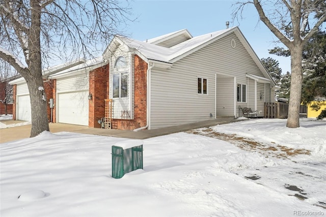 view of snowy exterior with a garage