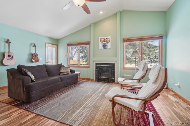 living room featuring a fireplace, hardwood / wood-style floors, high vaulted ceiling, and ceiling fan