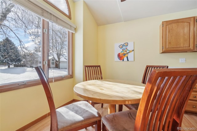 dining area featuring lofted ceiling and light wood-type flooring