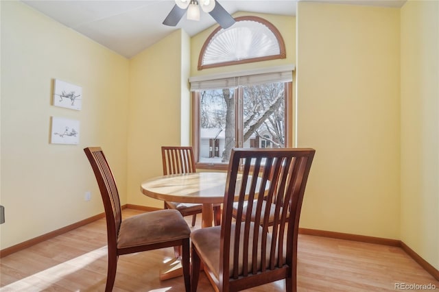 dining space featuring vaulted ceiling, ceiling fan, and light hardwood / wood-style flooring